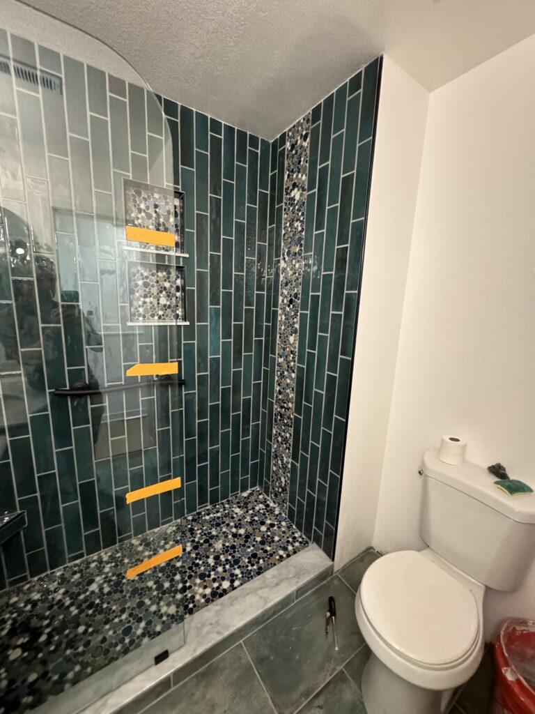 Walk-in shower with glass doors and contemporary tiling, installed during a full bathroom remodel by Papa's Home Improvements